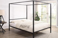 black metal four poster canopy bed frame in a bedroom